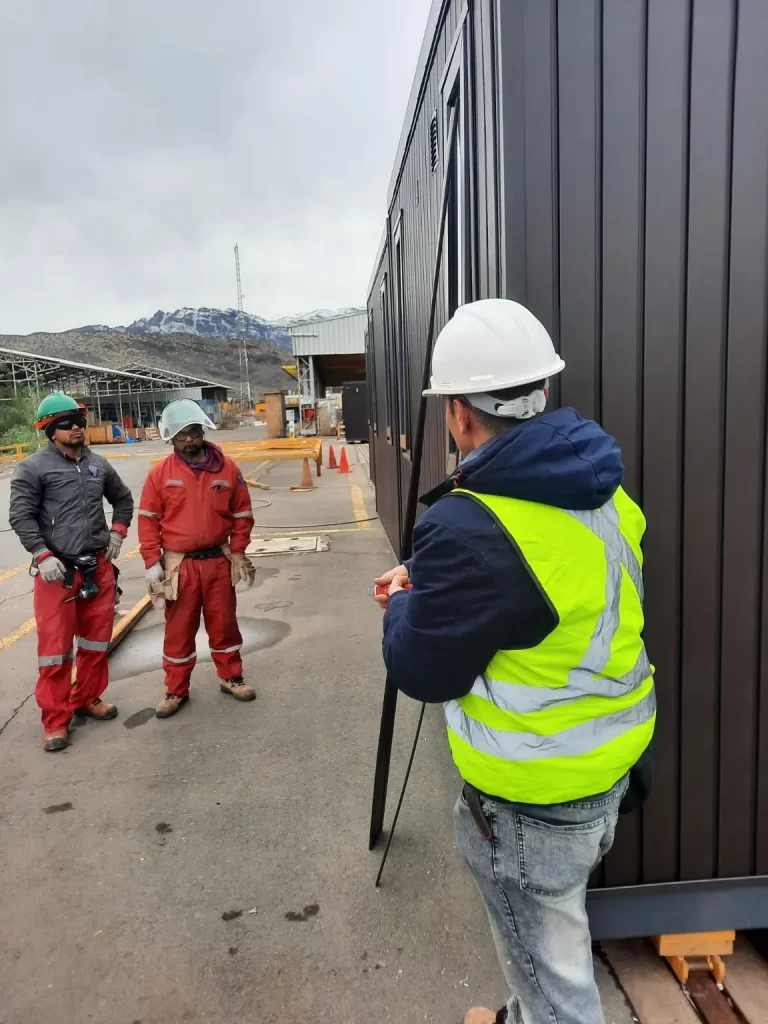 Personal de obra con equipo de seguridad revisando revestimiento exterior